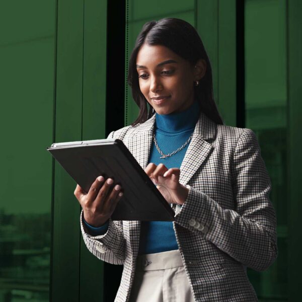 Business professional using a tablet to review digital documents in a modern office setting.